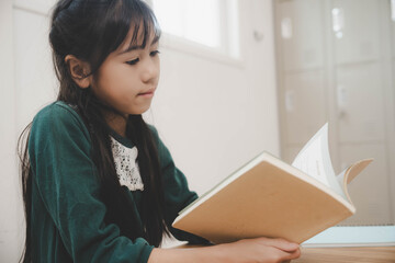 Asian school asian girl reading a text book in classroom