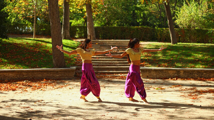 Indian female dancers performing traditional movements in park