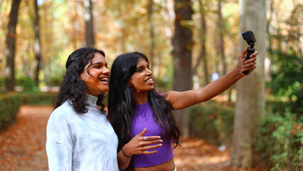 Fototapeta premium Happy young women filming video blog in autumn park