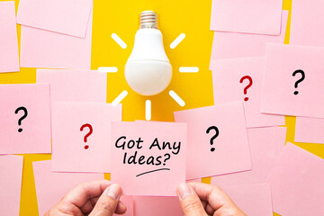 Hand holding sticky note with idea question mark