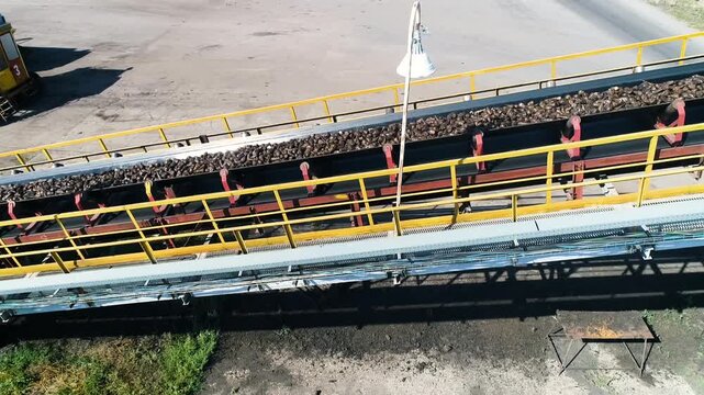 Russia. Summer day. Dolly shot, tracking. Materials are moved through an elevator for use in production against the backdrop of an industrial plant.
