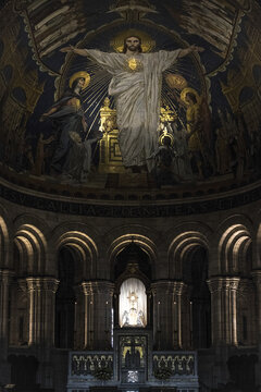 View of the ornate mosaic of Jesus Christ with open arms above the altar, framed by arches and pillars in the basilica, Paris, &Atilde;Žle-de-France, France.