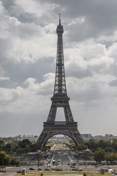 View of the Eiffel Tower rises majestically against a cloudy sky, framed by lush greenery and a bustling cityscape, Paris, &Atilde;Žle-de-France, France.