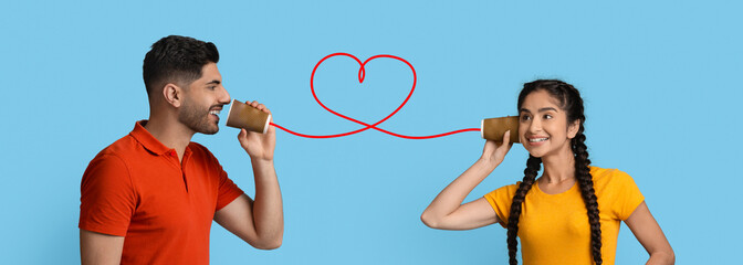 Two friends, a girl in a yellow shirt and a boy in a red shirt, smile while using a tin can telephone. A red string connects their cups, symbolizing friendship and connection.