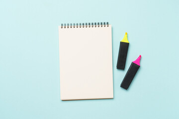 Sketch book and markers on blue background. Flat lay image with space for text.