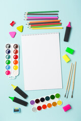 Naklejka premium Sketch book, markers, watercolor paints and pencils on blue background. Art creative composition with space for text.