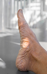 Close up of senior man foot with shadow on the floor.