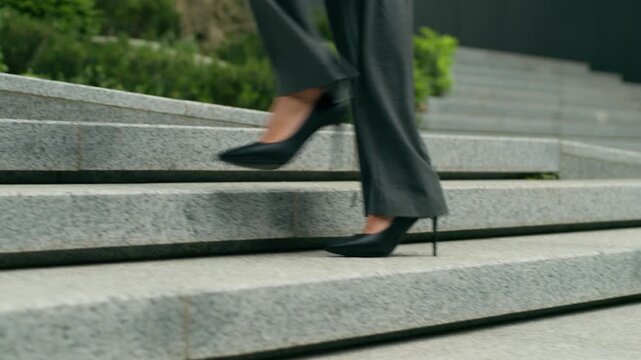 Unrecognizable stylish African American business woman walking upstairs in city cropped view female legs feet moving office stairway fashion girl high heels urban professional businesswoman outdoors