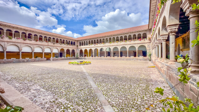 Aerial view of sunlight kissing the ancient stone courtyard of the Palacio Arzobispal, where shadows dance beneath the arched colonnades, Cusco, Peru.