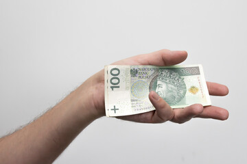 Męska dłoń trzymająca banknoty, złotówki, Zdjęcie na białym tle. © hunter76