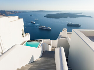 White architecture in Santorini island, Greece. Blue sea and the blue sky at sunset. Cruise ships near the shore.