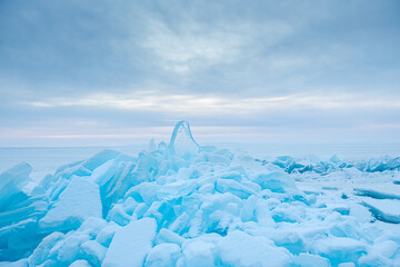 Blue ice with snow on Baikal lake at sunrise. Baikal, Russia.