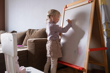 Little Girl Writing Numbers on Whiteboard with Marker.