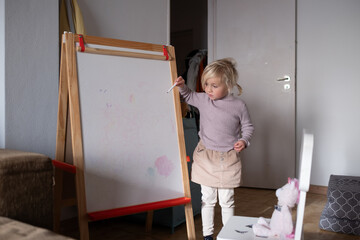 Little Girl Writing Numbers on Whiteboard with Marker.