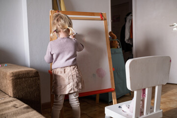 Little Girl Writing Numbers on Whiteboard with Marker.