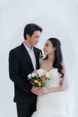 Asian couple getting married, Happy Asian couple in wedding attire, Bride wearing a beautiful white wedding dress and groom in a classic suit