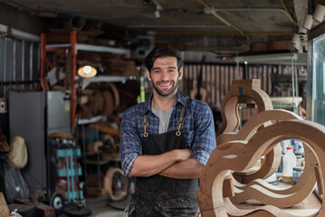 Portrait of guitar luthier small business owner in workroom.