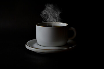 Hot Coffee with Steam in a white cup on a dark background.
