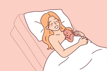 Fototapeta premium Smiling woman lies in a hospital bed with her newborn baby resting on her chest. Concept of skin-to-skin bonding and the golden hour immediately after a successful delivery in a clinic.