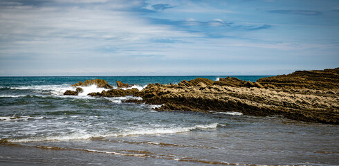 itzurun beach or zumaia beach in spain with blue sky