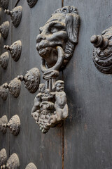 The Cathedral of Lima features a masterful display of colonial craftsmanship, particularly in the intricate metalwork of its massive wooden doors. These ornate bronze knockers and decorative studs