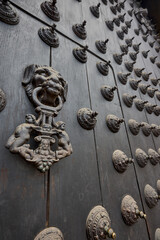 The Cathedral of Lima features a masterful display of colonial craftsmanship, particularly in the intricate metalwork of its massive wooden doors. These ornate bronze knockers and decorative studs
