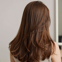 Obraz premium A girl with long, flowing brown hair is depicted in a care and beauty product-themed rear view