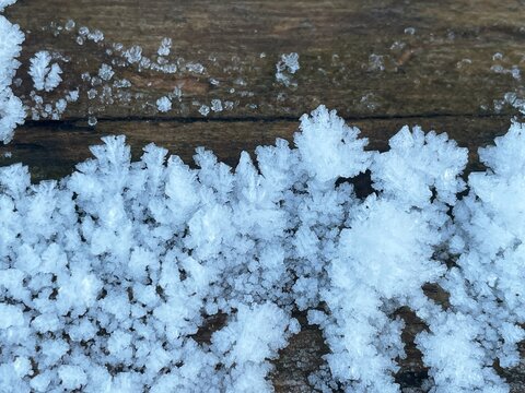 Intricate frost crystals forming delicate patterns on a cold surface. Close-up view of delicate ice formations and frost patterns created by freezing temperatures and moisture in the air