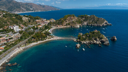 Fototapeta premium Aerial view of Isola Bella, a tidal island located on the eastern coast of Sicily, in province of Messina, Italy. It's a wonderful summer tourist destination.On the horizon, it's the Mediterranean Sea