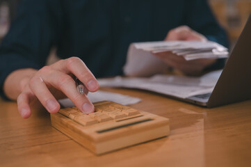 Businessman hand using calculator to budgeting and tax calculation monthly expenses. budget management and accounting on table. Business finance accounting banking concept.