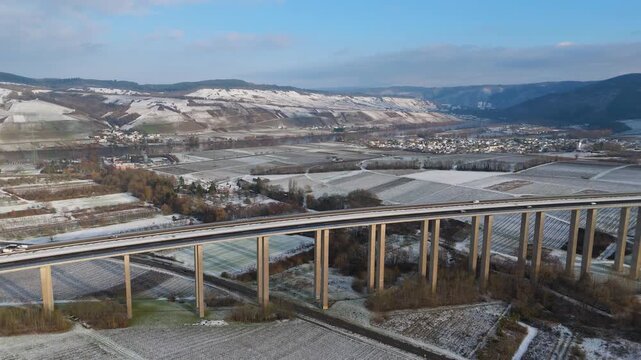Moselle vineyard, Viaduct Longuich, Mosel valley, snow in winter season, bridge of highway crossing river near Trier, aerial view