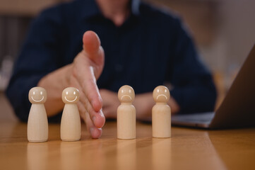 Businessman hand blocking and divide between group of wooden figure for resolving conflict and mediate management concept.