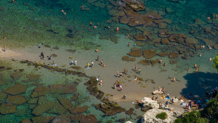 Aerial view of the emerald transparent sea, where massive underwater boulders create a dark mosaic...