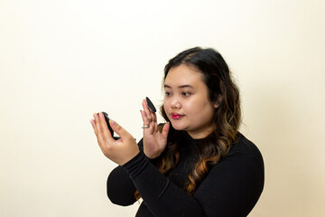 Young Woman Applying Makeup Using Compact Mirror and Powder Puff