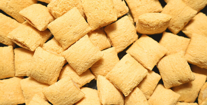 Corn puffs. Breakfast cereal texture. food background