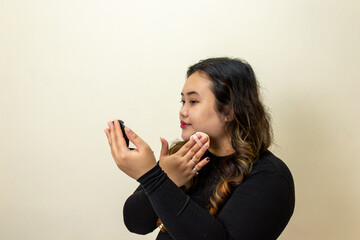 Young Woman Applying Powder Makeup with Compact Mirror and Puff