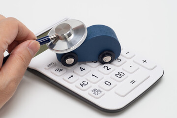 自動車の模型と電卓と聴診器で見積もりのイメージ