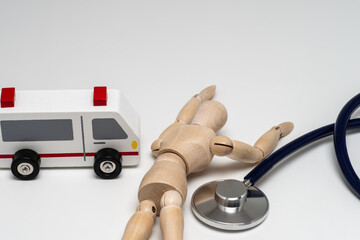 倒れた人形と救急車と聴診器