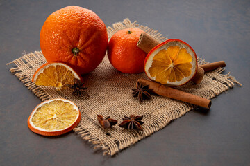 Dried orange slices, cinnamon and star anise on a brown wooden background. Spices for mulled wine