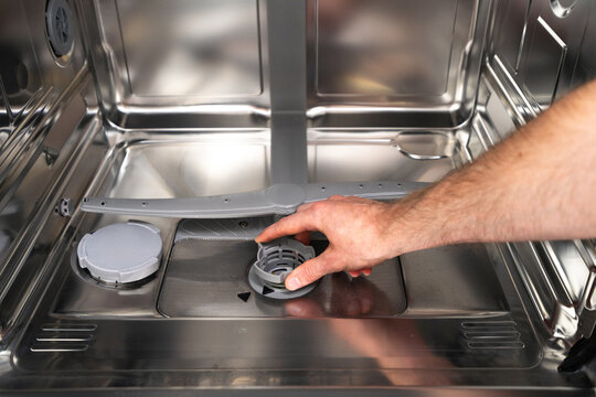 Repairing a broken dishwasher in a modern kitchen apartment