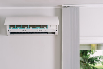 Air conditioner unit mounted on white copy space wall in a modern apartment living room
