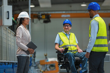 A female manager oversees teamwork in a factory while a worker in a wheelchair and a male operator discuss tasks and safety.