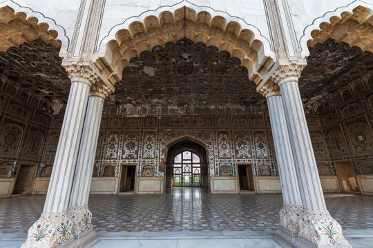View of intricate marble carvings adorn the arched entrance and pillars of a historic building with ornate walls and floors, Lahore, Punjab, Pakistan.