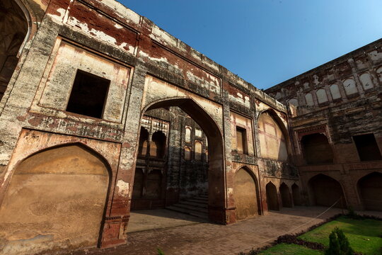 View of weathered walls and arched doorways create a mesmerizing play of light and shadow within the historic Lahore Fort, Lahore, Punjab, Pakistan.