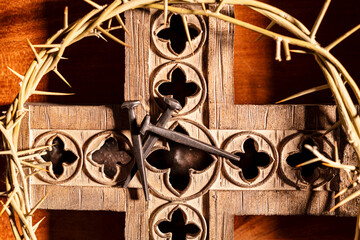 extreme close up of wood cross crown of thorns and rose head nails
