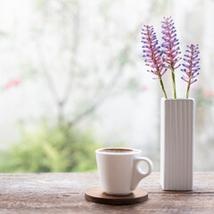 White coffee cup and Aechmea gamosepala, Matchstick Bromeliad in a vase