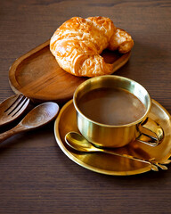 Hot coffee with a croissant.