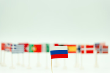Various country flags displayed with focus on a small Russian flag in front on a white background