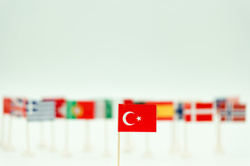 Flags from different countries are placed in a row with a focus on the Turkish flag in the foreground