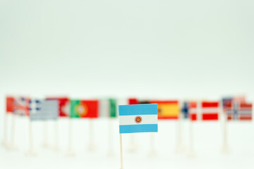 Multiple small flags of different countries displayed on a flat surface with an emphasis on one flag at the front